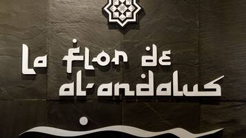 A sign with Arabic text and a geometric logo, likely indicating a hotel or establishment.