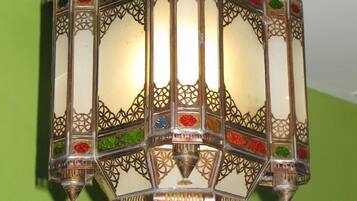 Una lámpara de pared detallada y ornamentada, con intrincados trabajos en metal y paneles de vidrio de colores.