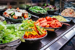 A buffet with various dishes including salads, vegetables, and a meat dish. - The Eldan Hotel (Jerusalem)