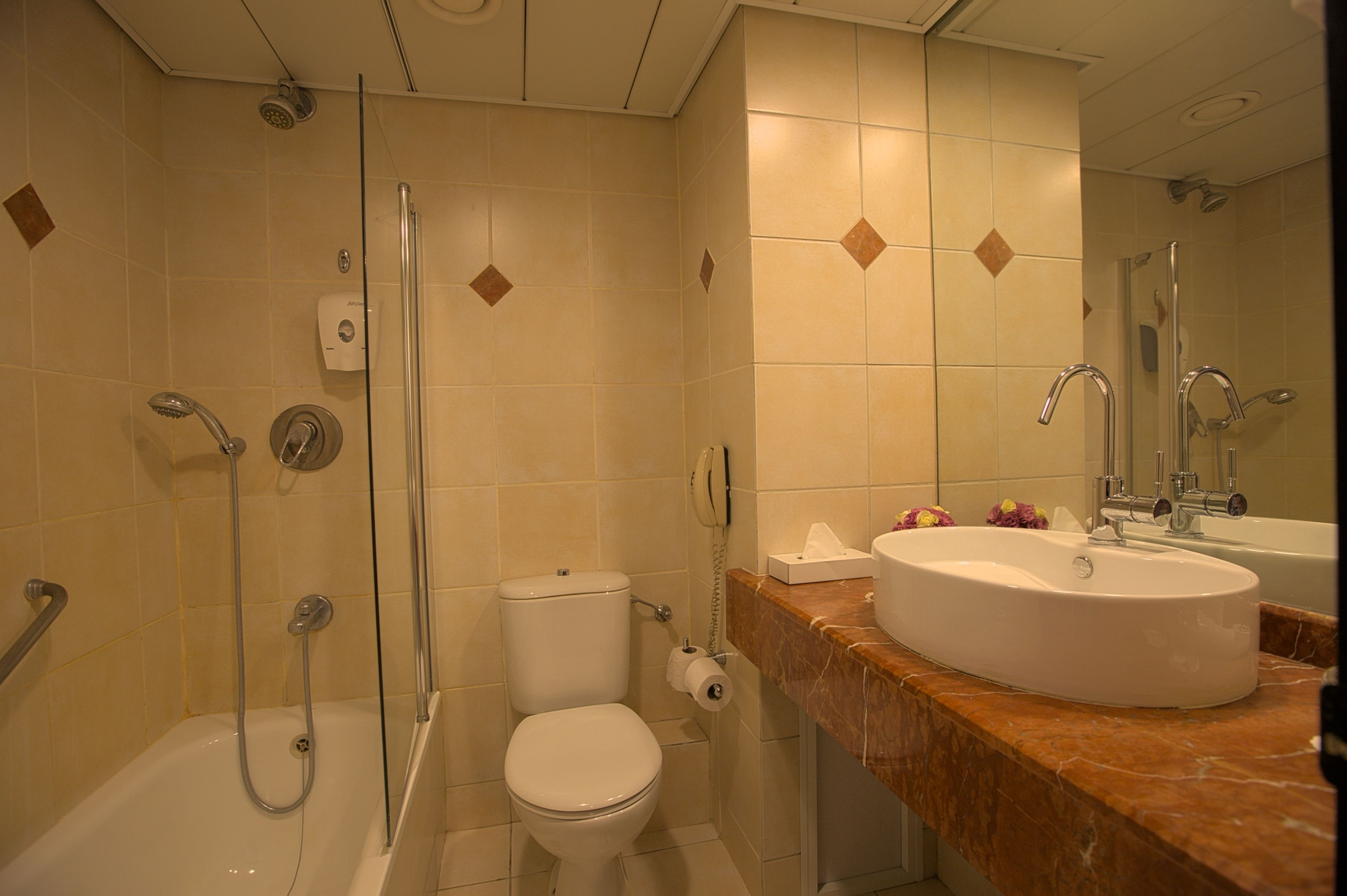 A bathroom with a shower, toilet, and sink.
