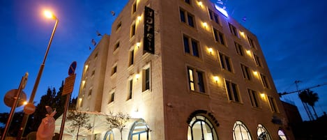 A hotel with a classic architectural style, featuring arched windows and a prominent sign.