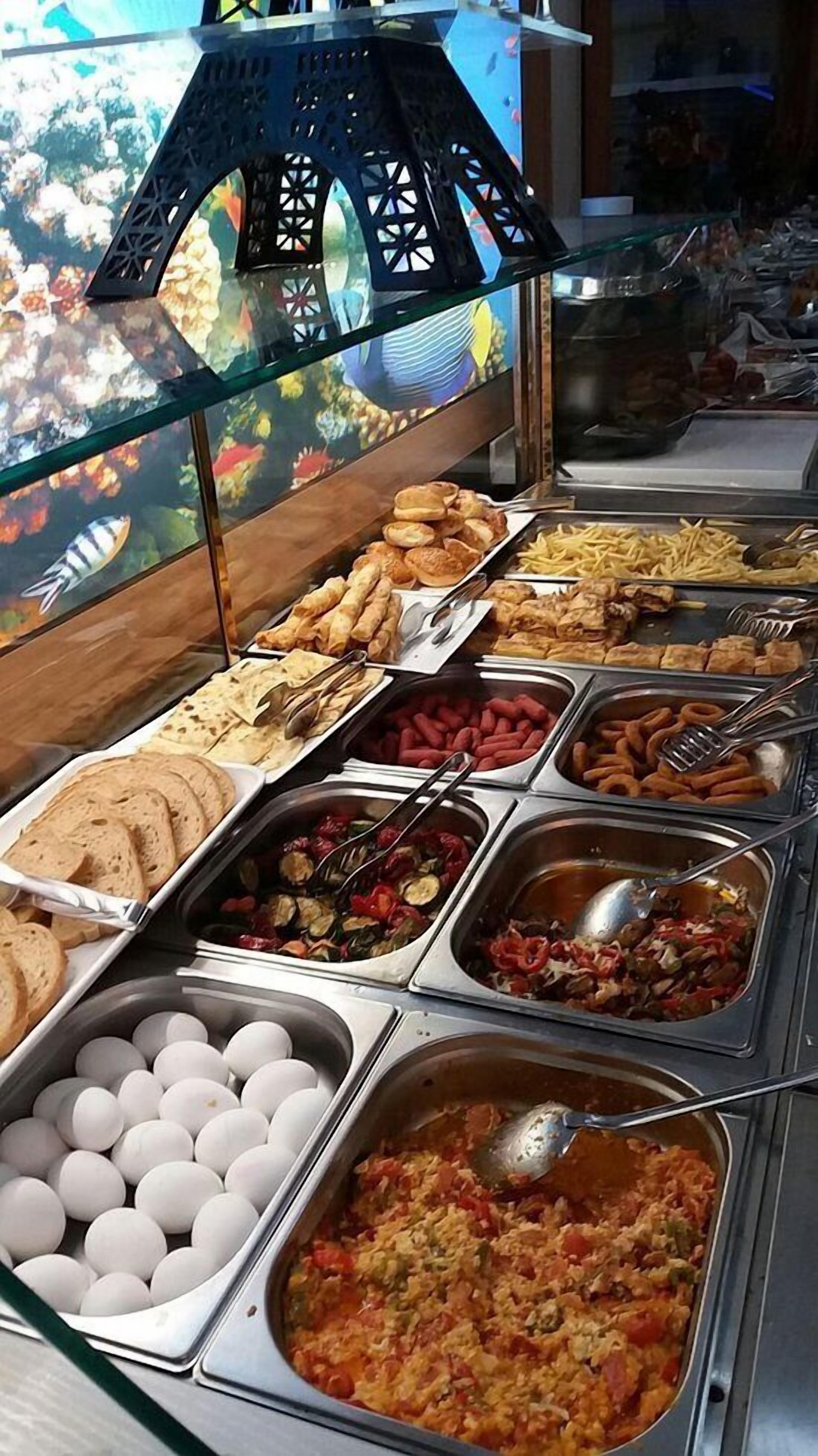 A buffet with various food options including eggs, bread, and a variety of dishes in metal containers.