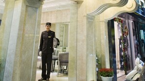 A hotel entrance with a grand archway, a reception desk, and a uniformed attendant. - Classy Boutique Hotel (Hanoi)