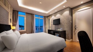 A hotel room with a large bed, a desk with a flat-screen TV, and a door. - Classy Boutique Hotel (Hanoi)