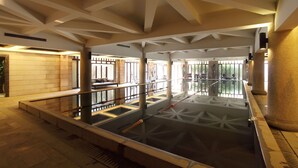 A spacious indoor pool area with a geometric ceiling design and a central water feature. - Nanjing Baliyuanshu Vogue Hotspring Hotel (Nanjing)