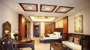 A hotel room with a bed, sofa, dining table, and a large mirror. - Nanjing Baliyuanshu Vogue Hotspring Hotel (Nanjing)