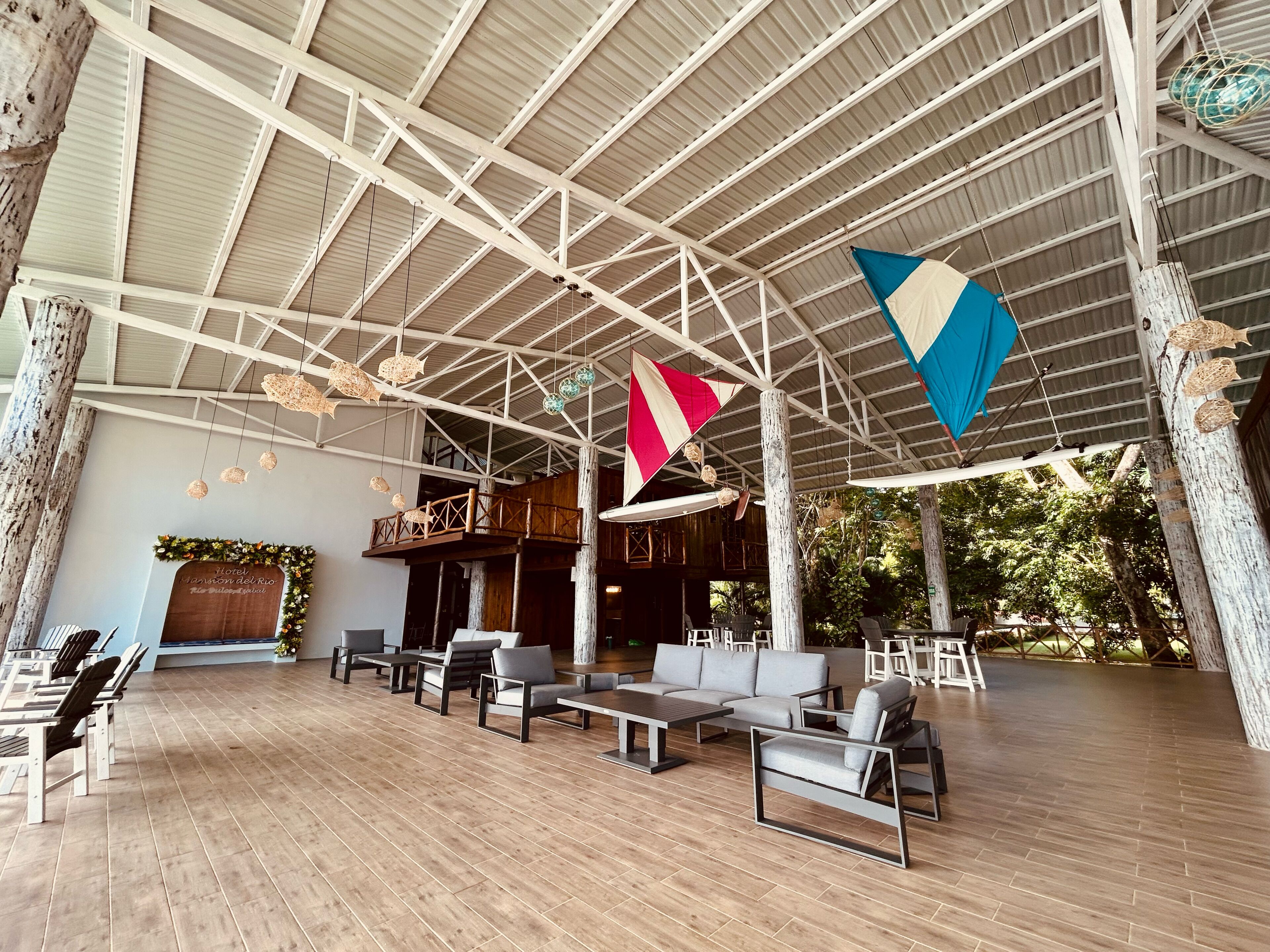 Un vaste espace intérieur doté d’un haut plafond, d’un plancher en bois et de différents types de sièges.