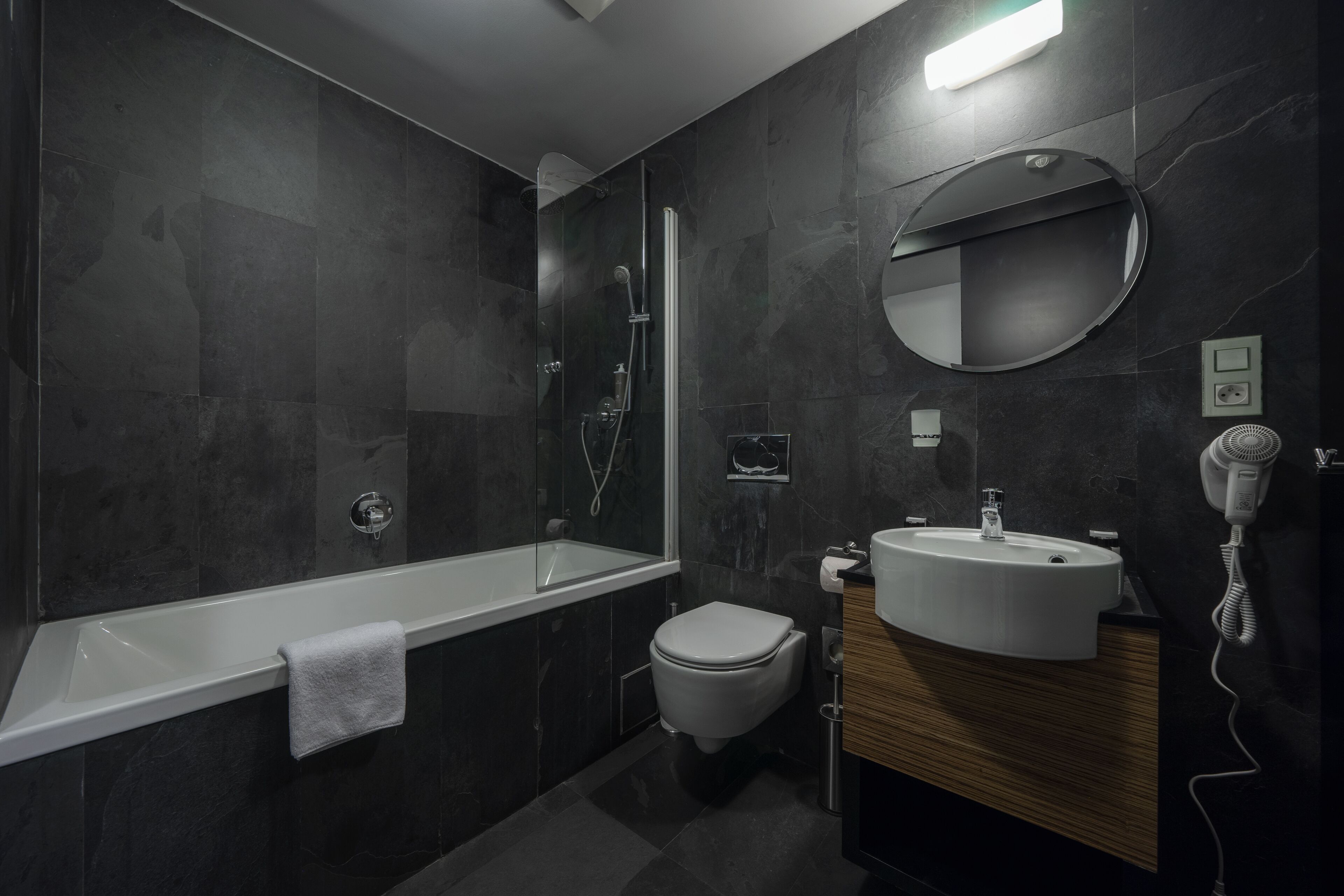 Ein modernes Badezimmer mit Badewanne, Toilette und Waschbecken.