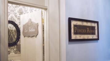 A hallway with a sign reading "Powder Room" on the wall.