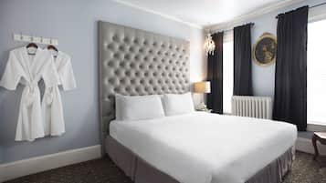 Ein ordentlich bezogenes Bett in einem Hotelzimmer mit einer gepolsterten Kopfstütze, einer Nachttischlampe und einer Heizung.