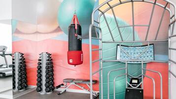 A gym with a punching bag, dumbbells, and a TRUETREK stretch band.