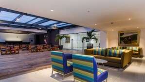 A spacious lobby with a high ceiling, modern seating arrangements, and a glass door entrance. - Wyndham Costa del Sol Tumbes (Tumbes)