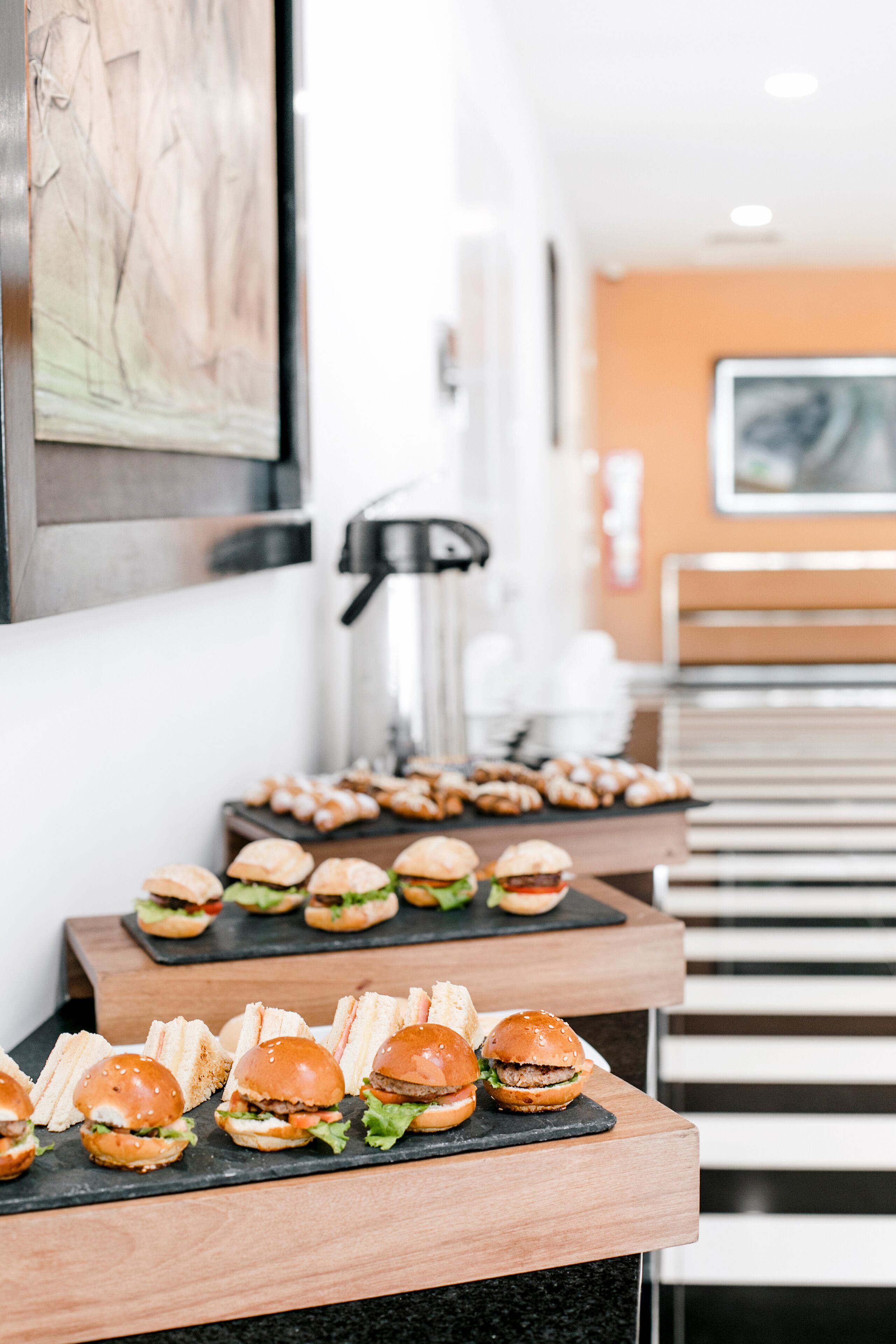 Una mesa de buffet con sándwiches y pasteles sobre tablas de madera.