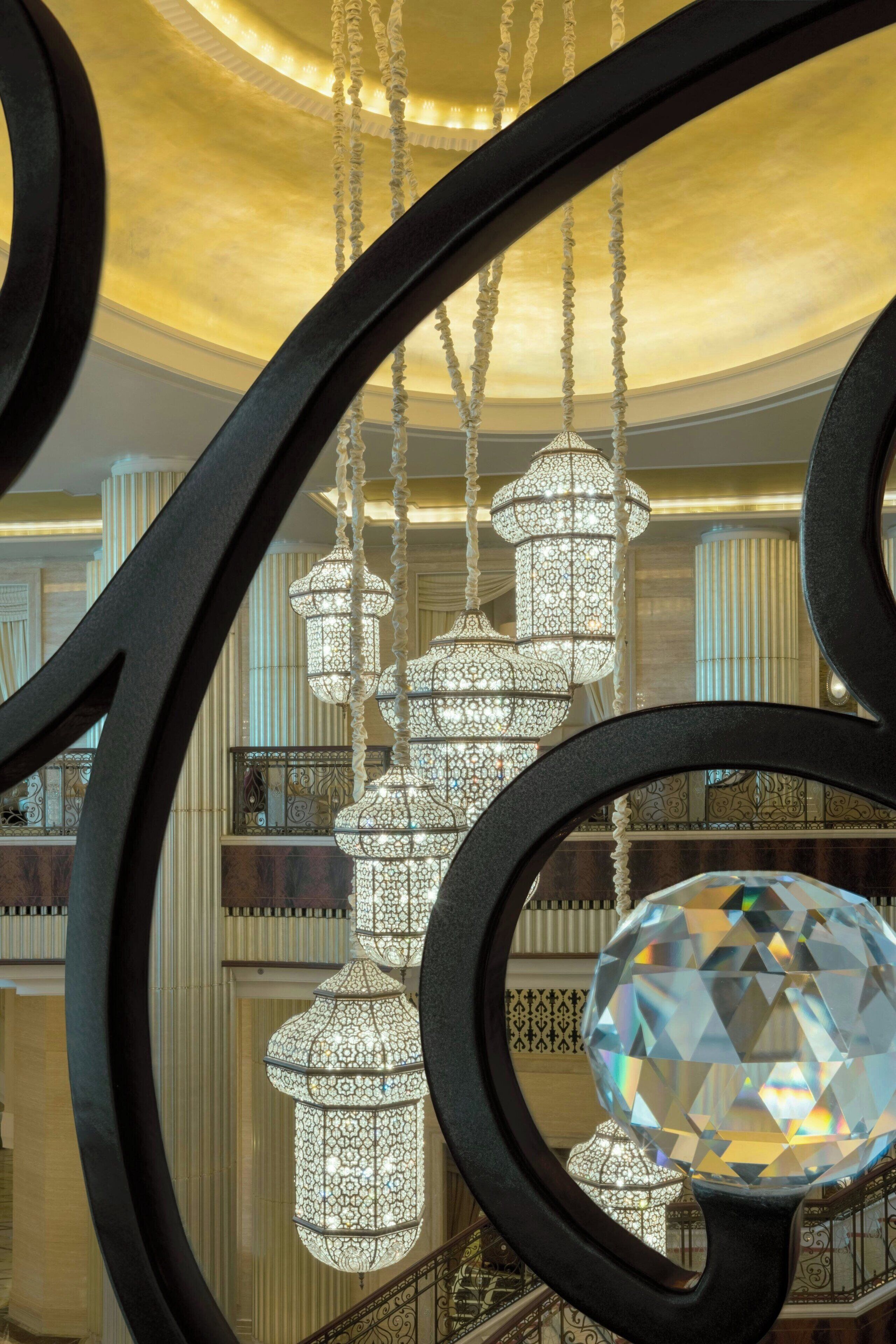 A chandelier with multiple hanging lights and a large crystal centerpiece in a luxurious interior.