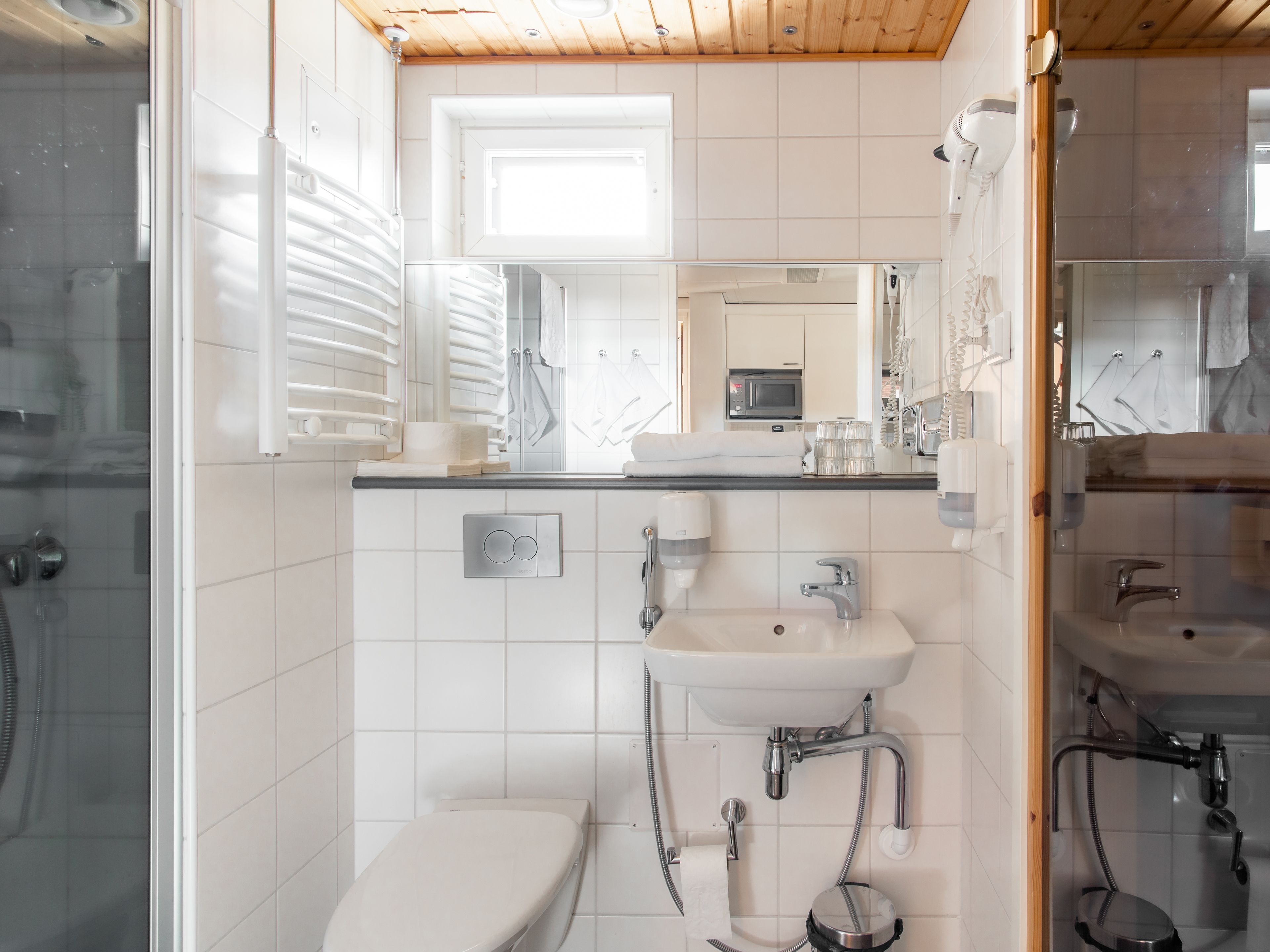 A modern bathroom with a toilet, sink, and shower.