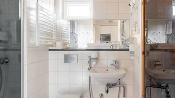 A modern bathroom with a toilet, sink, and shower.