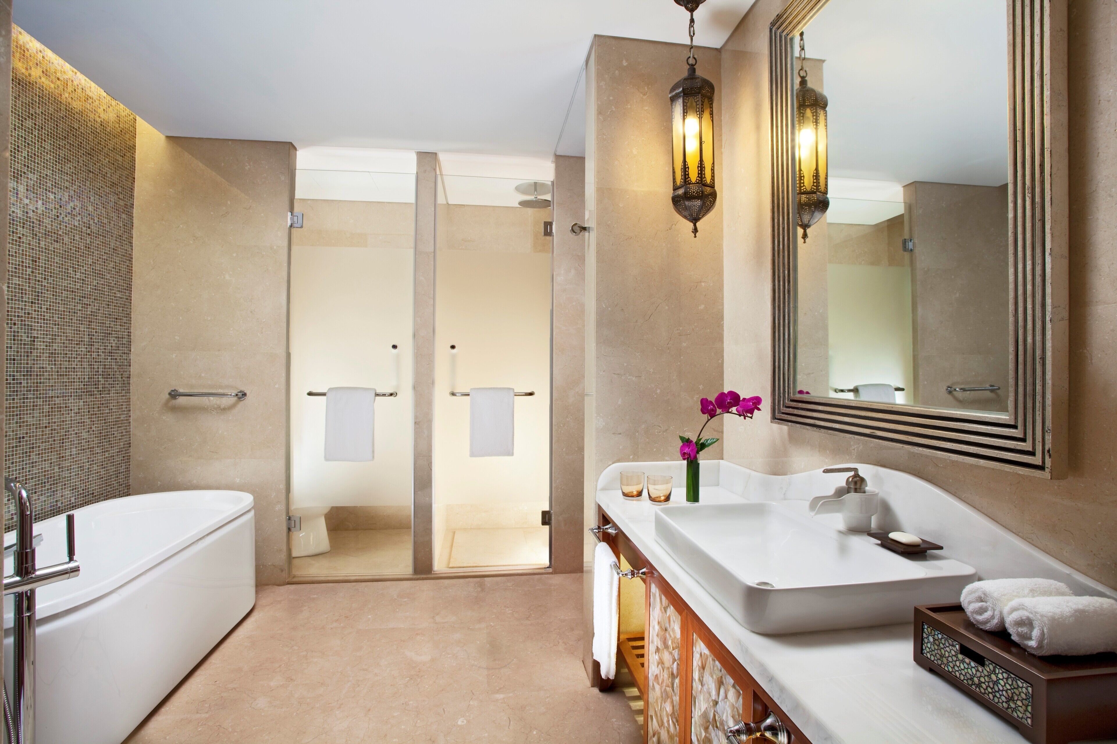 A modern bathroom with a bathtub, a large sink, and a glass-enclosed shower.