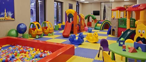 A children's play area with a ball pit, slides, and various play structures.