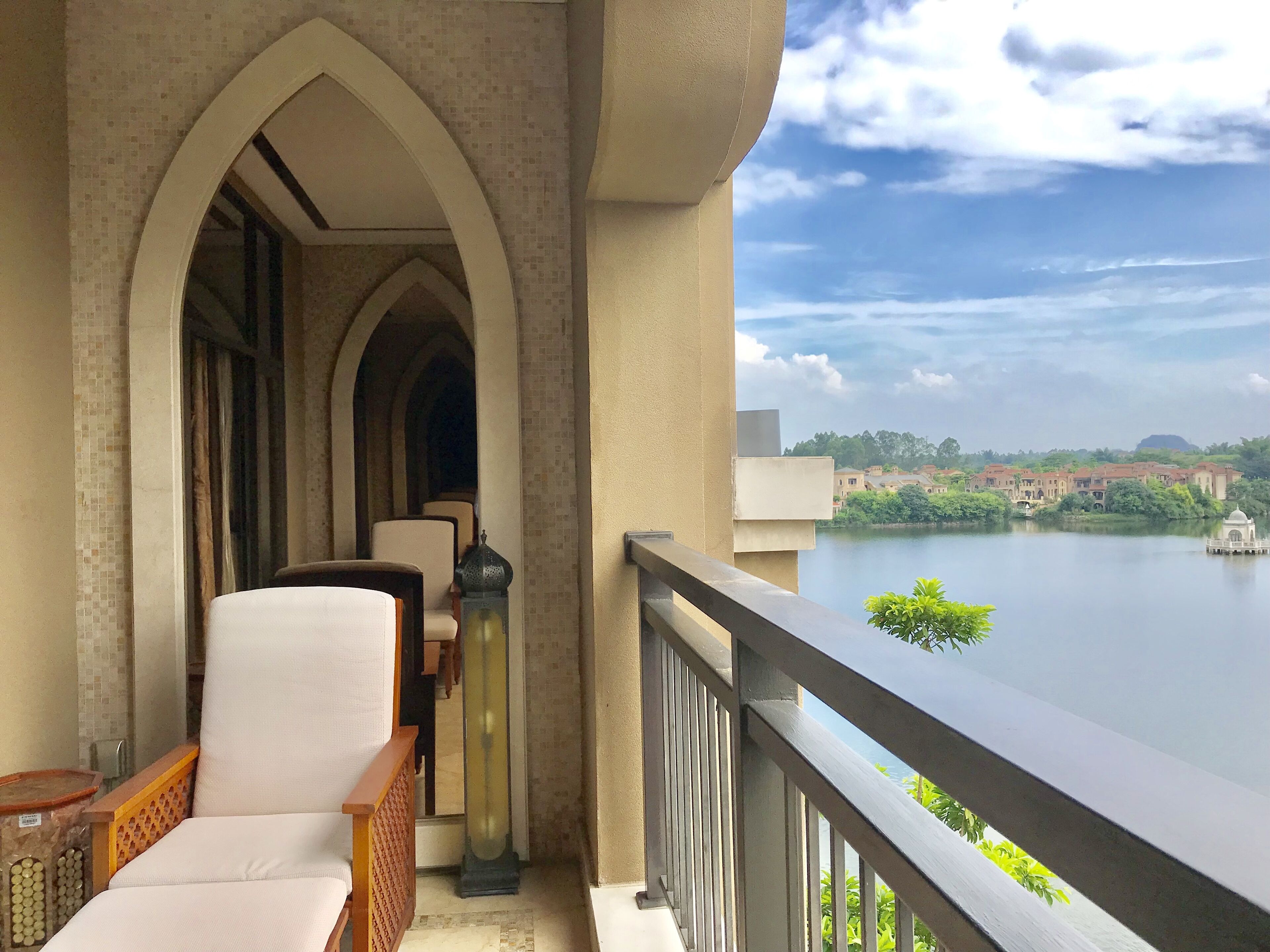 Un balcone con vista su un lago e edifici in lontananza.