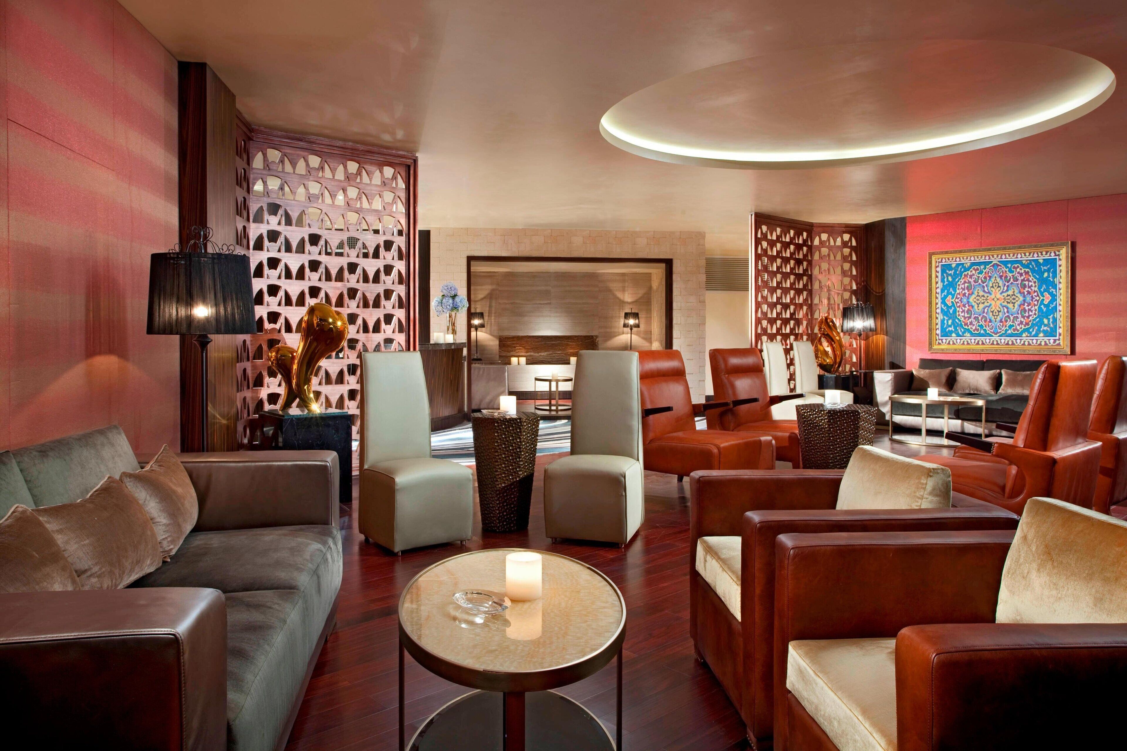 A modern lounge with leather sofas, armchairs, and a round coffee table.