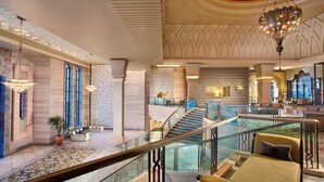 A spacious lobby with a glass railing, a central staircase, and a camel statue.