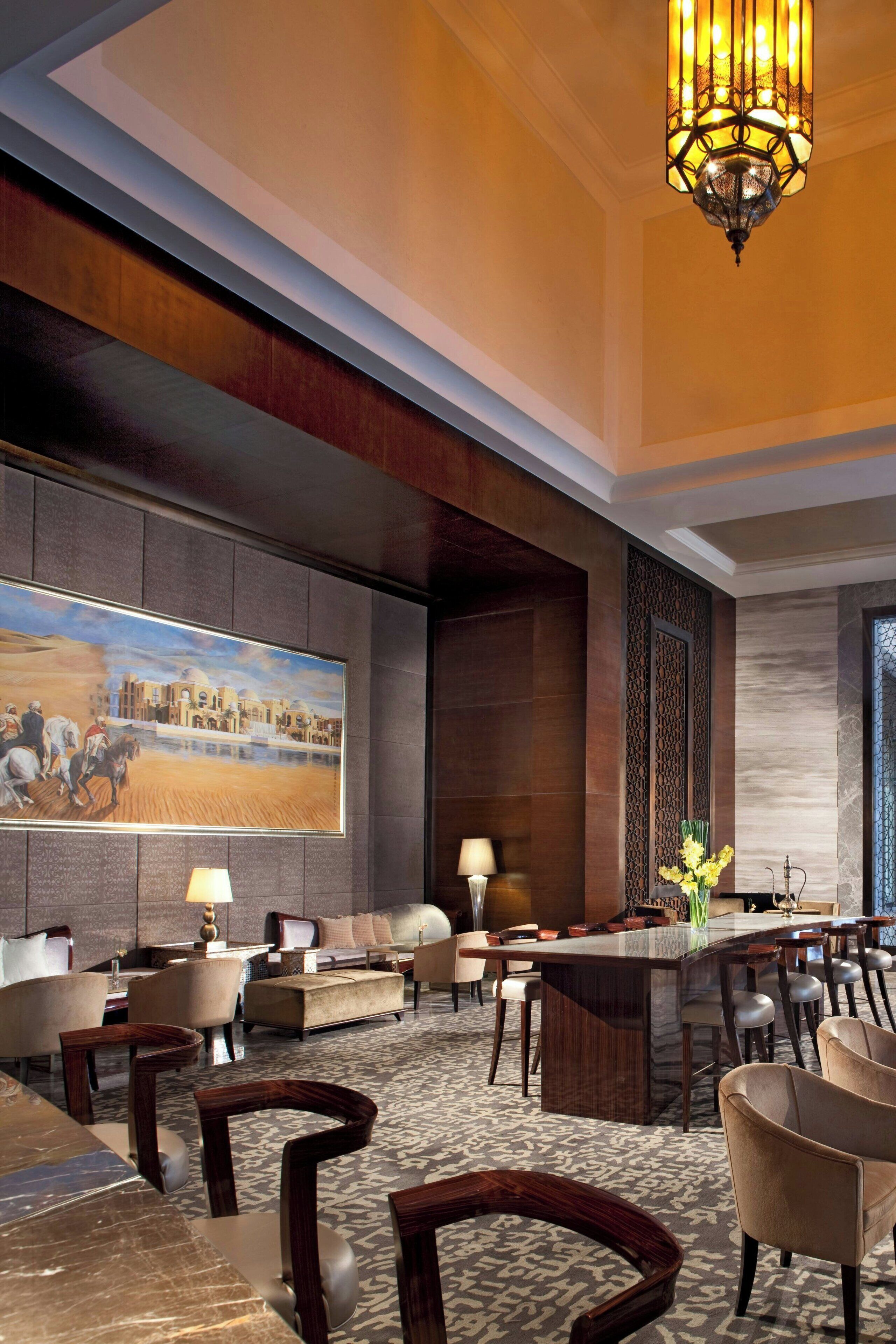 A lobby with a large painting, a bar area, and a seating arrangement.
