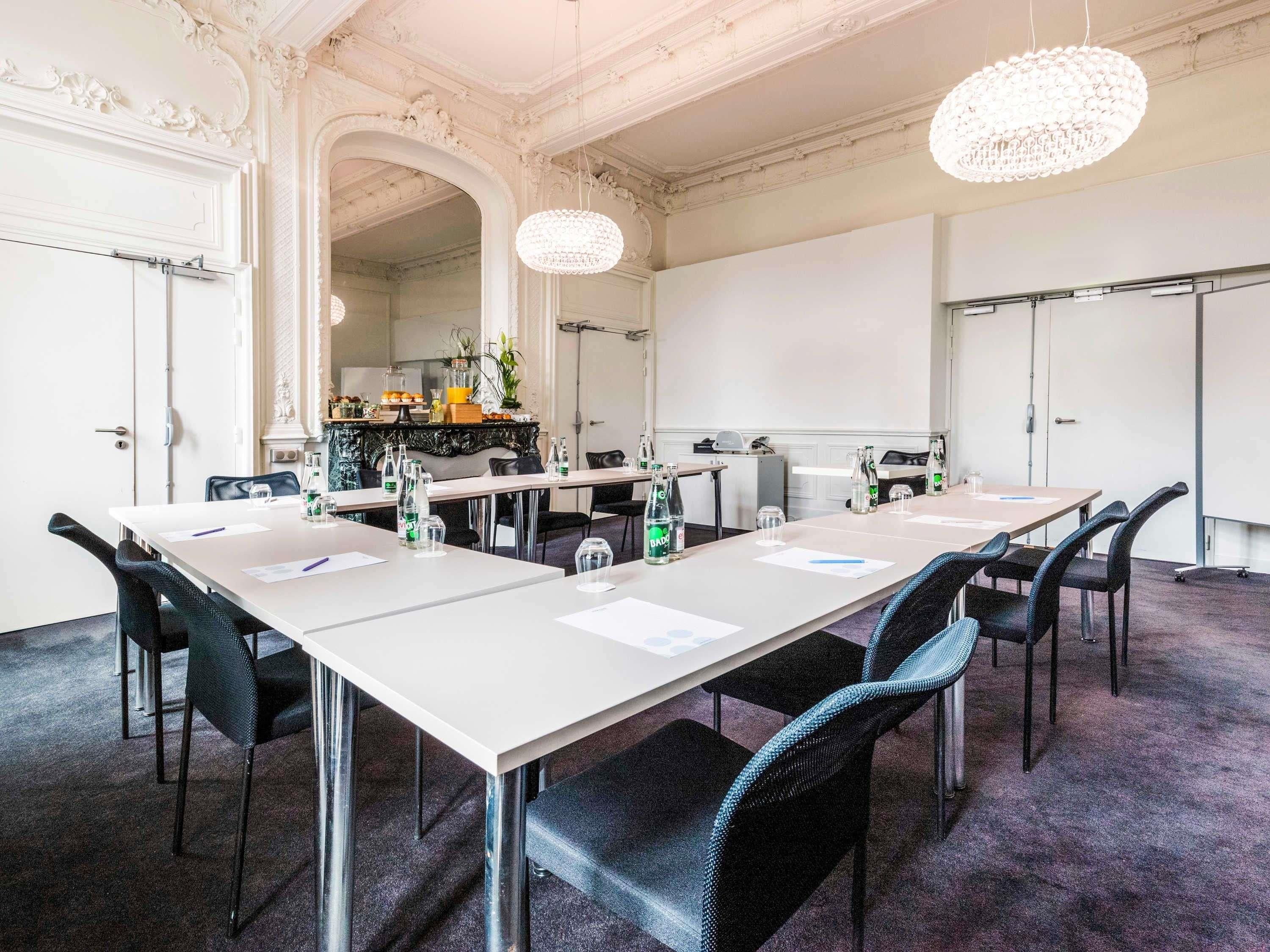 A conference room with a long table, chairs, and a chandelier.