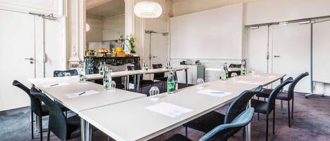 A conference room with a long table, chairs, and a chandelier.