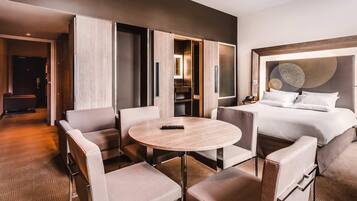 Ein Hotelzimmer mit einem Bett, einem runden Tisch und einer Sitzecke mit Stühlen.