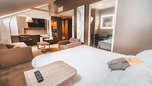 Une chambre d’hôtel avec un grand lit, un bureau, un canapé et une télévision.