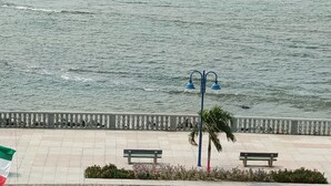 Un paseo marítimo con un banco, un farol y una bandera.