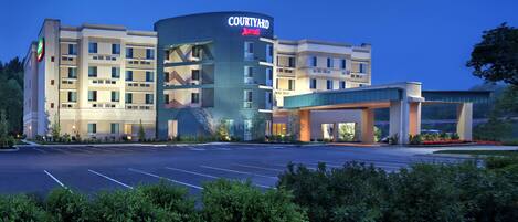 Un hotel Courtyard Marriott con diseño moderno, varios pisos y estacionamiento.