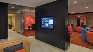Un hall d’entrée moderne doté d’un écran numérique, d’espaces de détente et d’un comptoir d’accueil.
