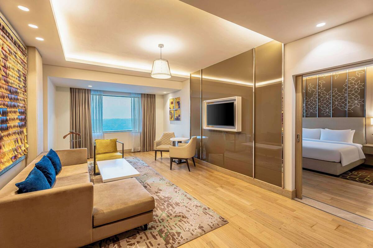 Ein modernes Hotelzimmer mit einer Couch, einem Sessel und einem Bett.