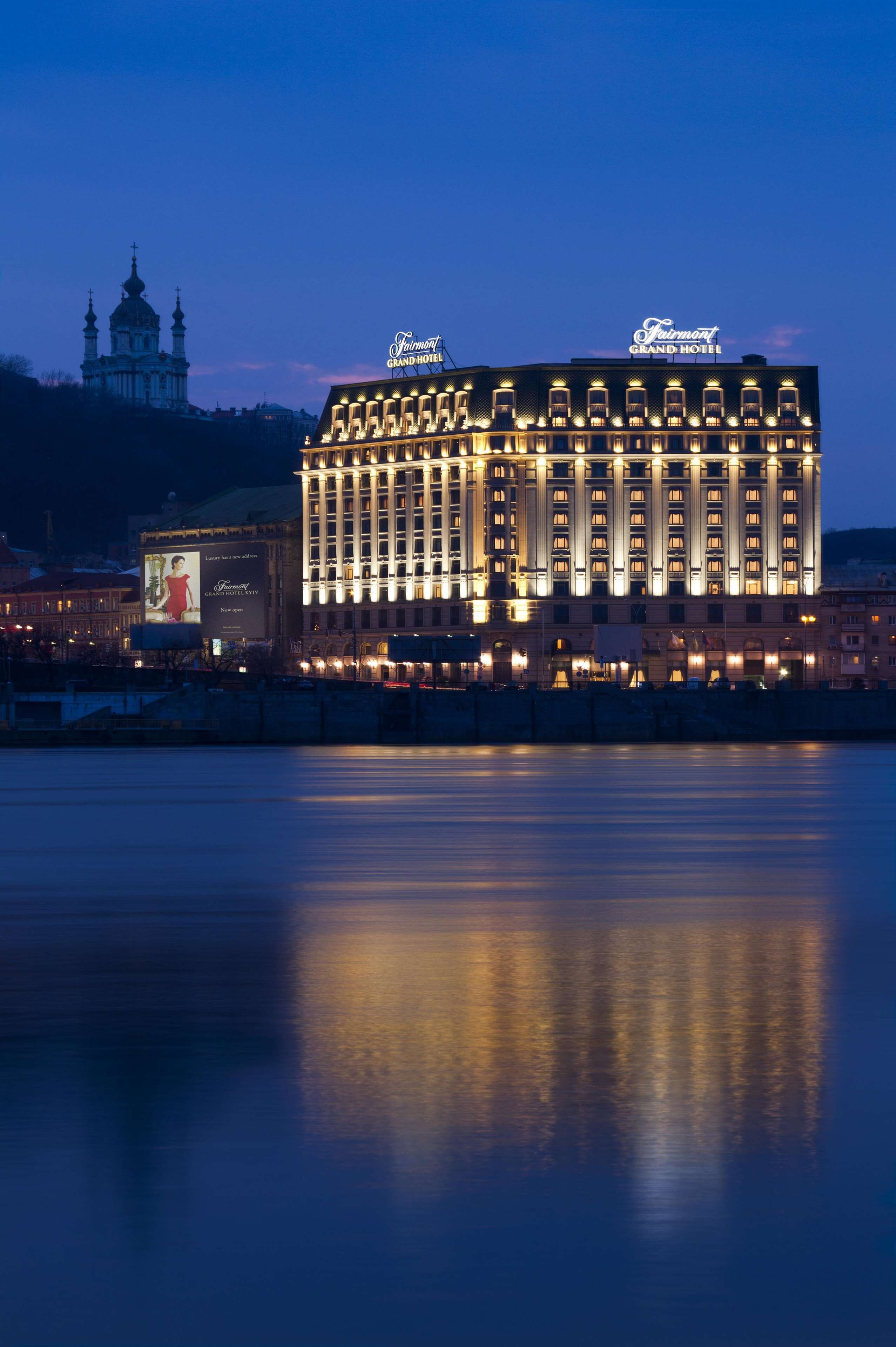 A large hotel with a prominent sign and a reflection in the water.