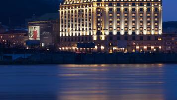 A large hotel with a prominent sign and a reflection in the water.