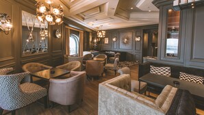 A spacious lounge area with multiple seating options, including sofas and armchairs, and a central coffee table.