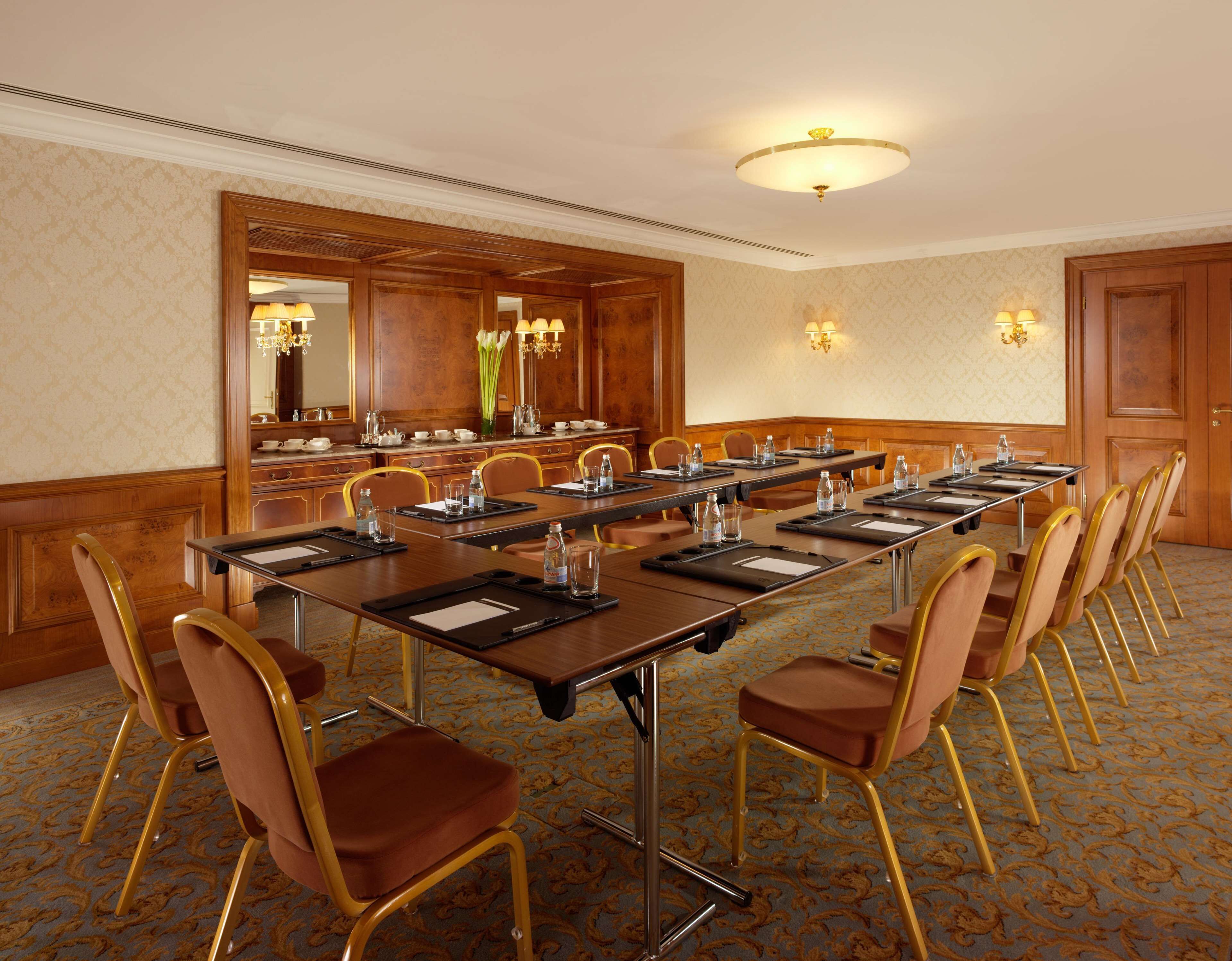 A conference room with a long table, chairs, and a mirror.