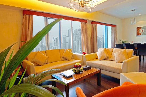 A modern living room with two sofas, a coffee table, and a dining area with a table and chairs.