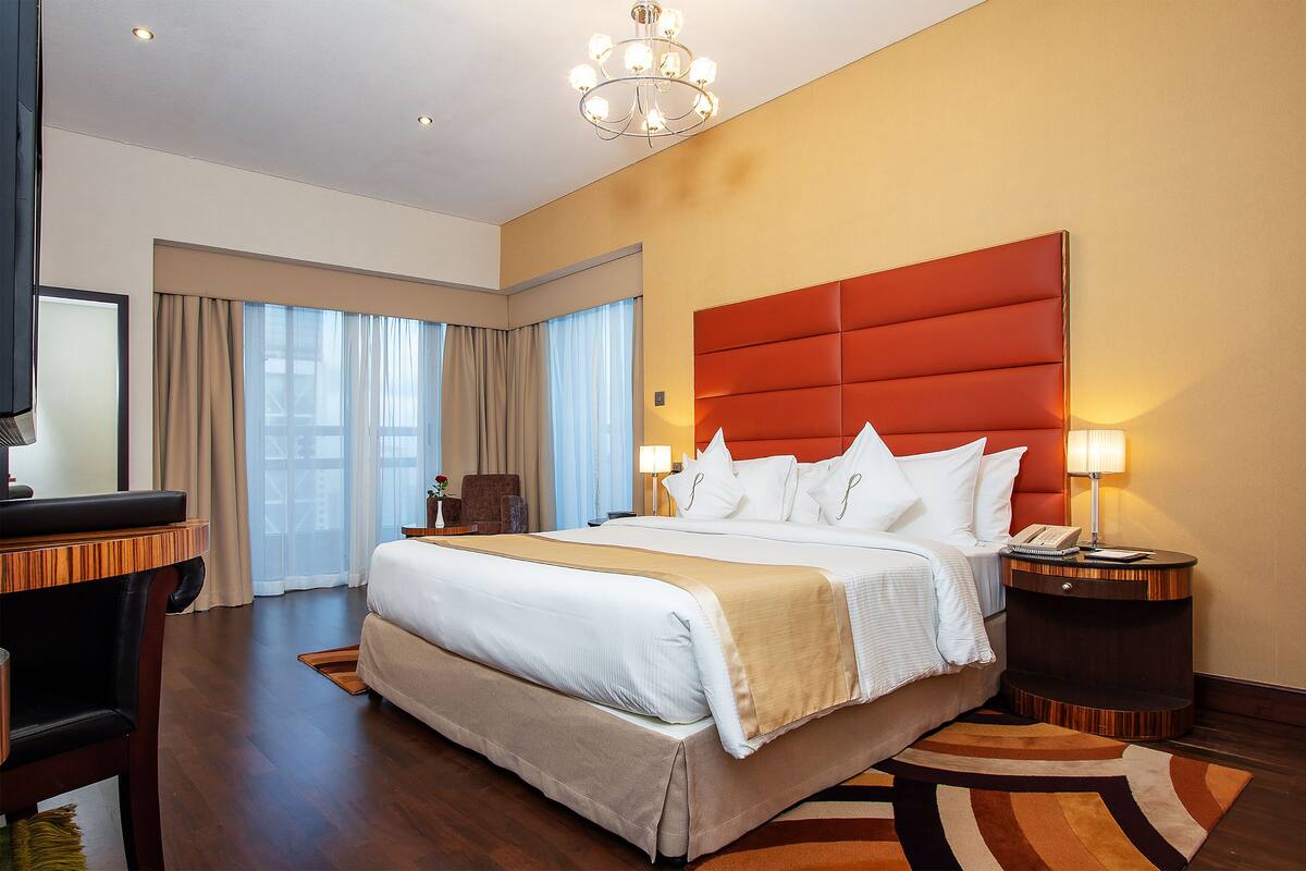 Habitación de hotel con una cama grande, un escritorio y una silla.