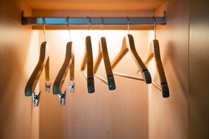 A row of wooden hangers hanging on a metal rod in a closet. - Hotel Ocean (Hualien City)