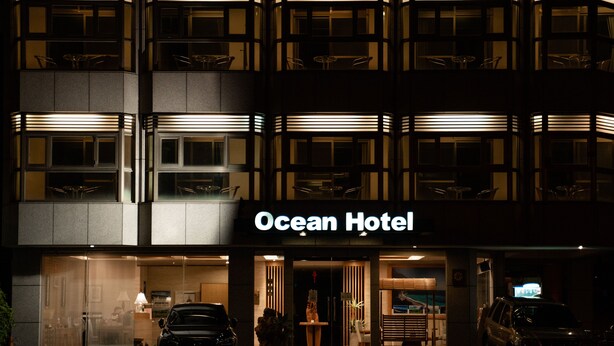 The exterior of the Ocean Hotel with a modern design, featuring a prominent entrance and a visible car parked in front. - Hotel Ocean (Hualien City)