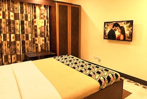 A hotel room with a bed, a television, and a patterned curtain. - New Dodoma Hotel (Dodoma)