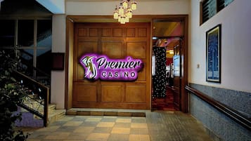 A wooden entrance door with a neon sign for Premier Casino.