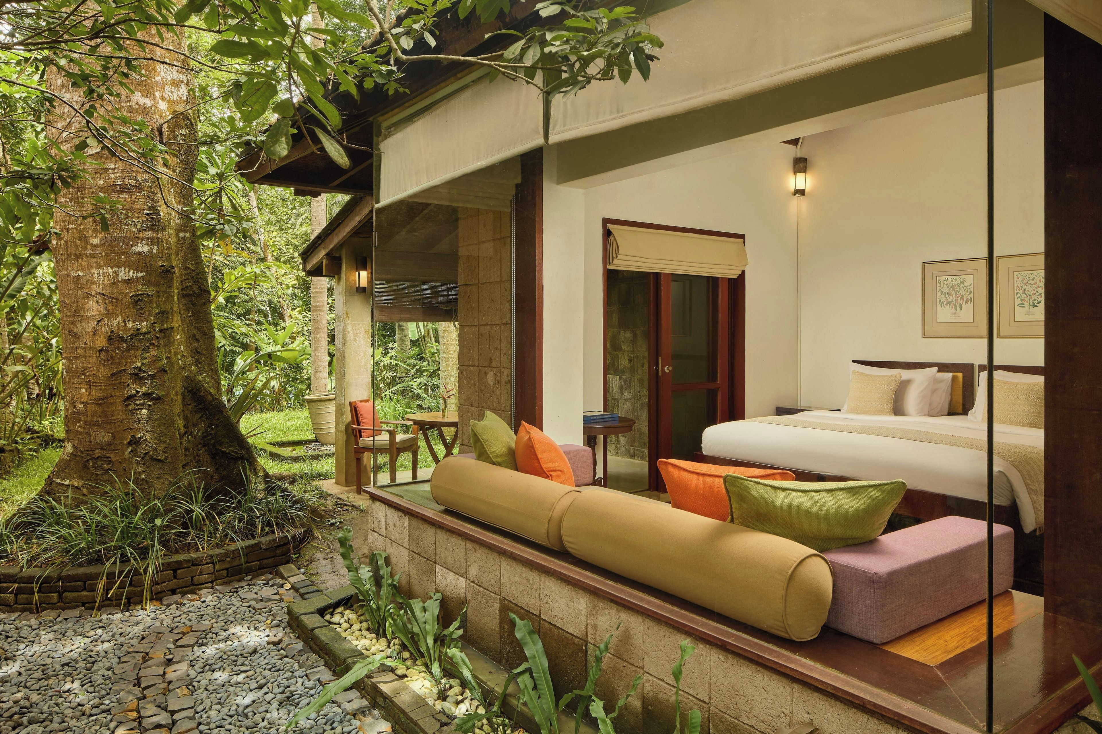 Una habitación con cama, sofá y ventana con vistas a un jardín.