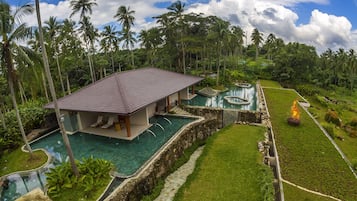 Un complexe hôtelier doté d’une piscine, d’un espace de détente couvert et d’un foyer.