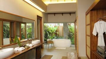 Un baño moderno con un espejo grande, un tocador de madera, una bañera y un armario de madera.