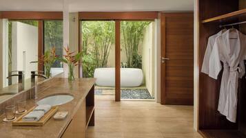 A modern bathroom with a large mirror, a sink, and a bathtub.