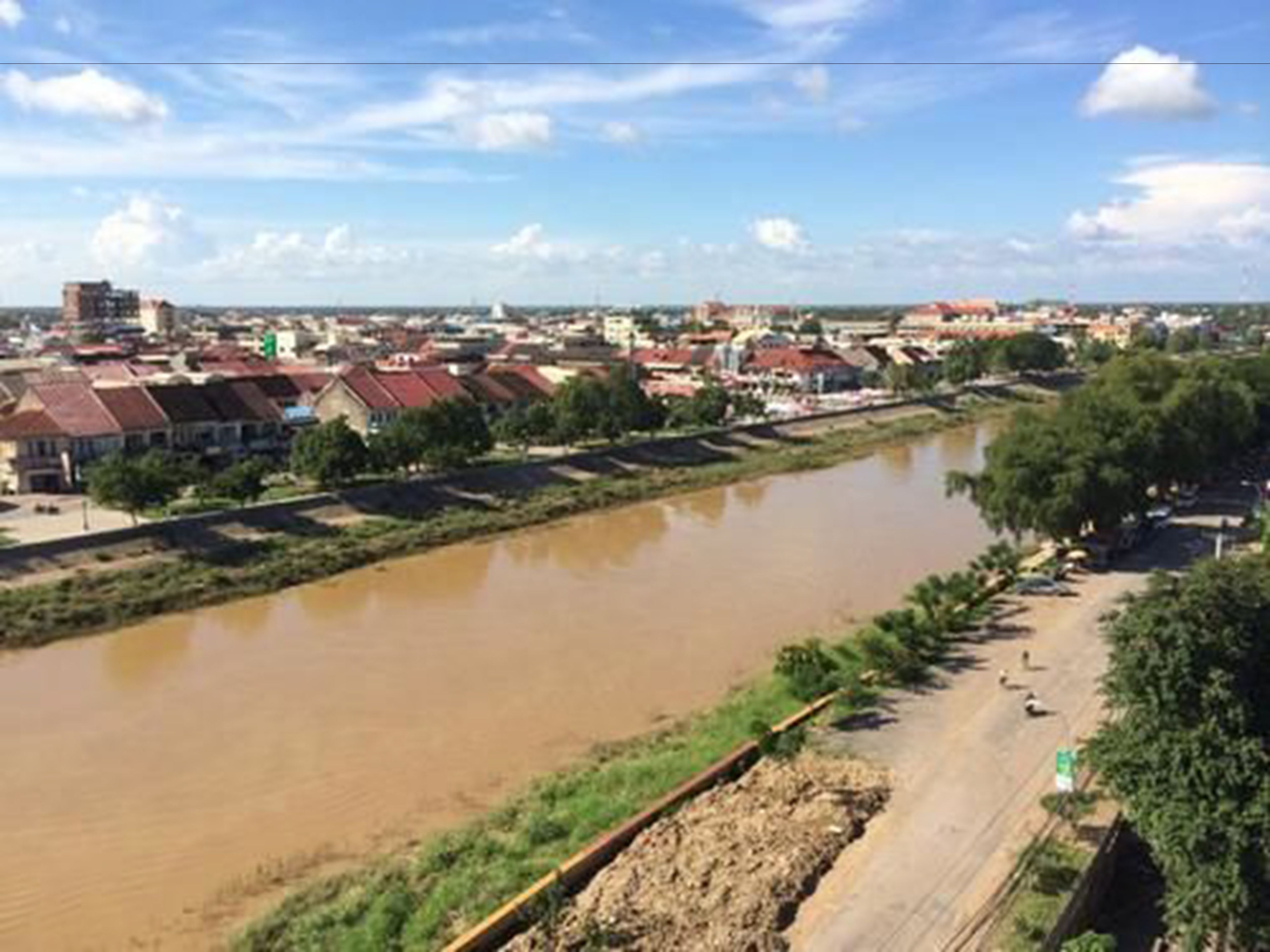 A river with a bridge and buildings along the riverbank.