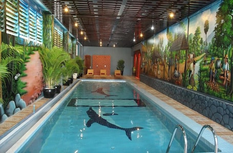 Una piscina techada, sillones reclinables de piscina